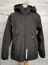 Load image into Gallery viewer, BOY SIZE 7/8 YEARS - REIMA Black Hooded Jacket EUC

High quality brand that&#39;s stylish and made really well. Perfect for spring and fall weather.  

Removable hood, reflective strips, side zippers, adjustable straps on inside, lined. 

Note* there is a stain on the back (see pic for reference) the actual stain isnt as noticeable in normal lighting. 

